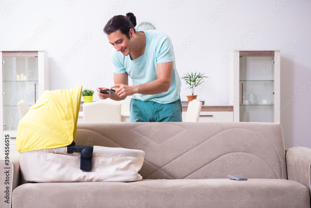 Obraz premium Young male parent looking after newborn at home