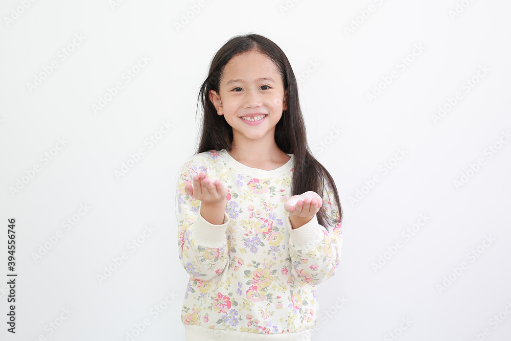 Cheerful asian little girl with lotion cream in hands on white background. Cheerful asian little girl with lotion cream in hands on white background.