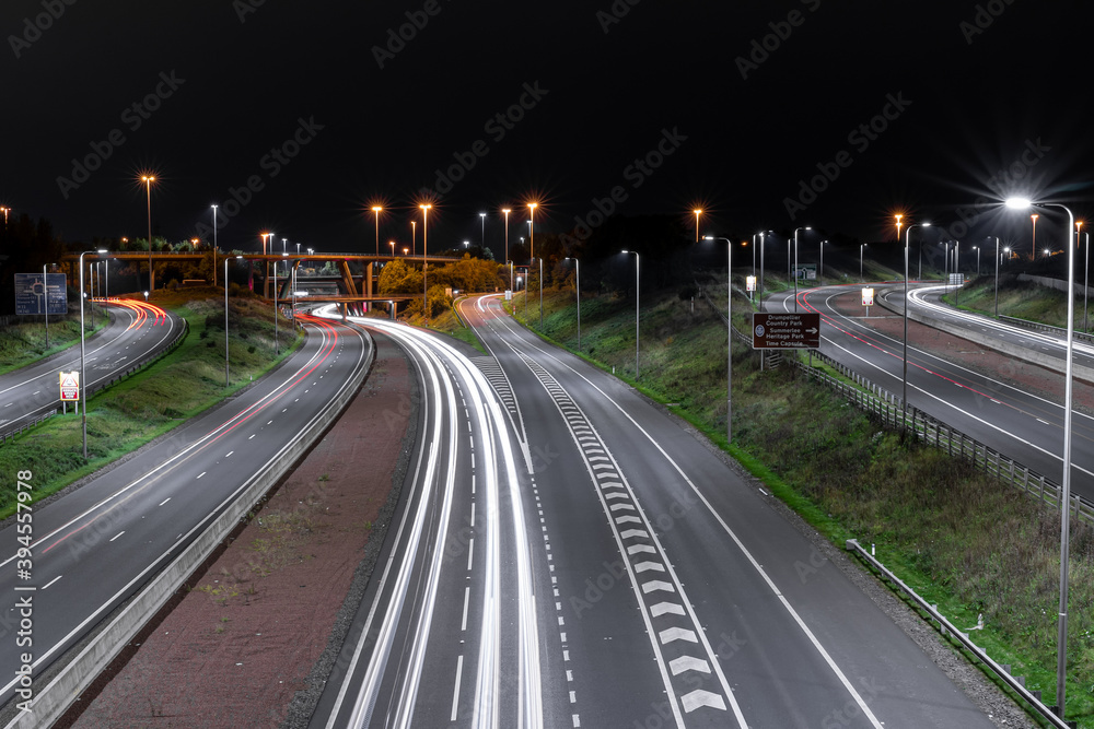 Autostrada nocą z latarniami i samochodami 