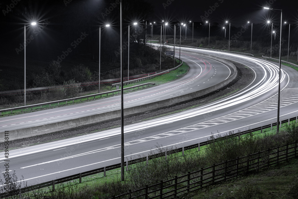 Autostrada nocą z latarniami i samochodami 