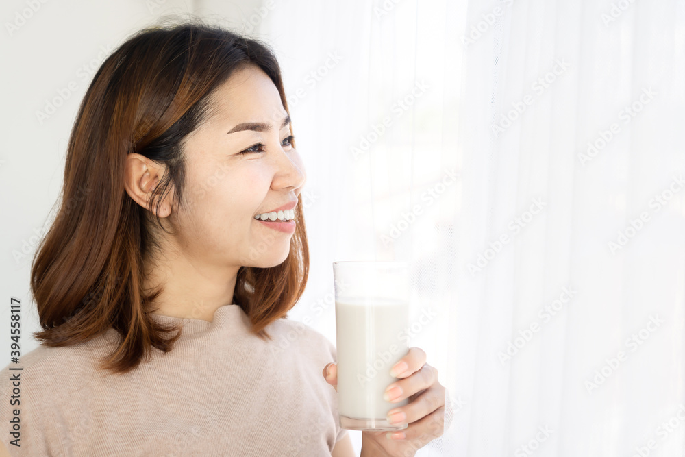 smiling Asian woman hand holding glass of milk happy drinking healthy smiling Asian woman hand holding glass of milk happy drinking healthy