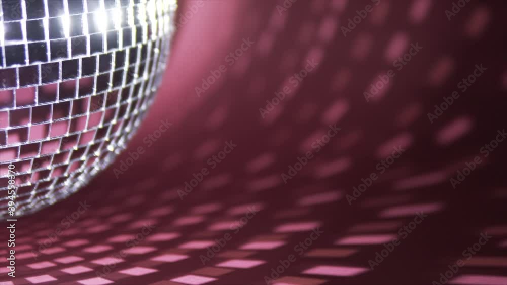 A mirror ball (disco ball) rotates on a red background. Abstract