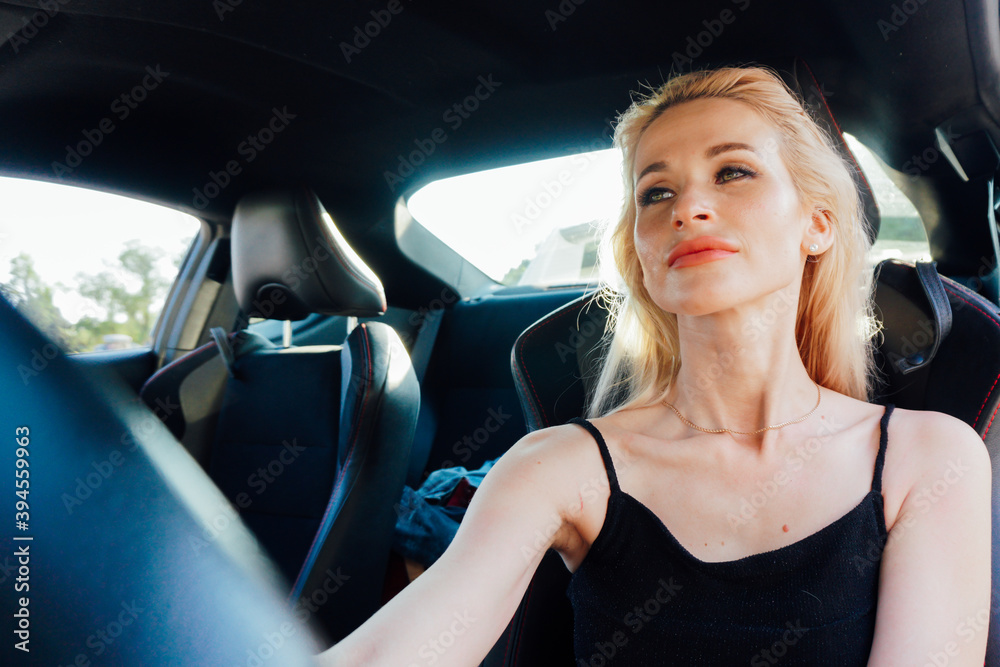 Beautiful female blonde driver behind the wheel of a car