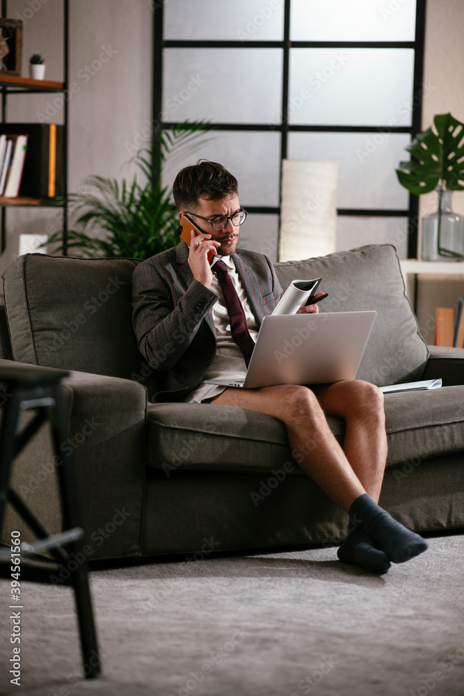 Businessman with no pants working at home. Young man using the laptop having video call. Businessman with no pants working at home. Young man using the laptop having video call.