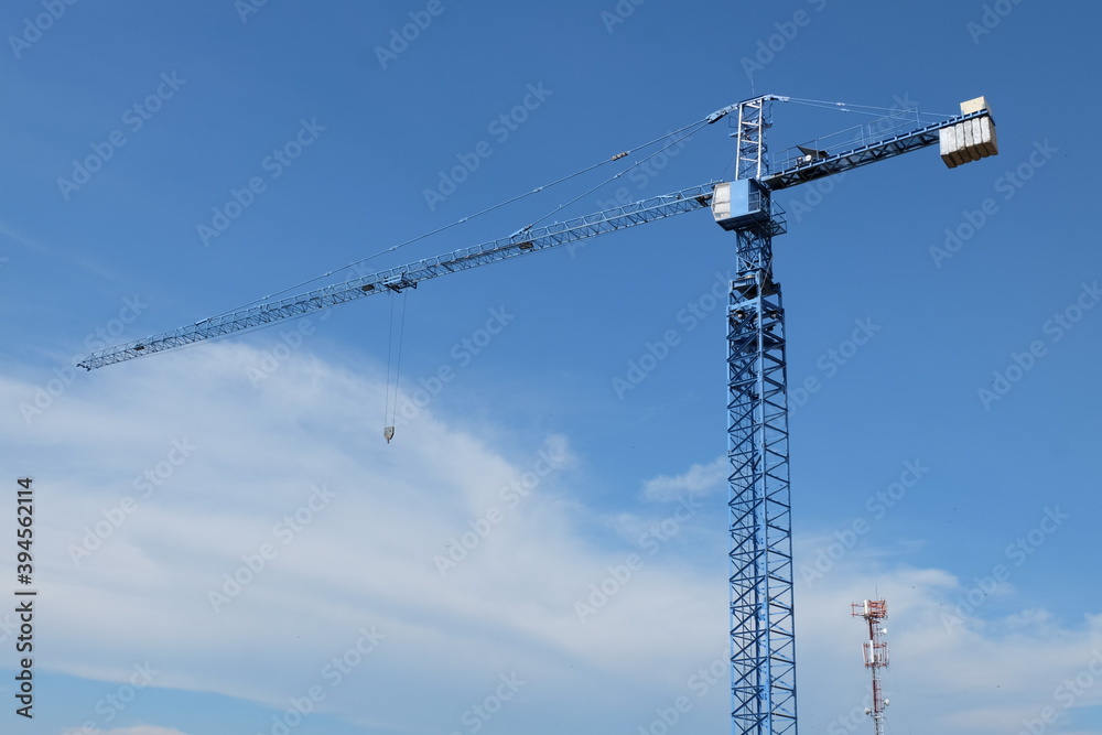 A large blue crane in the urban building construction area
