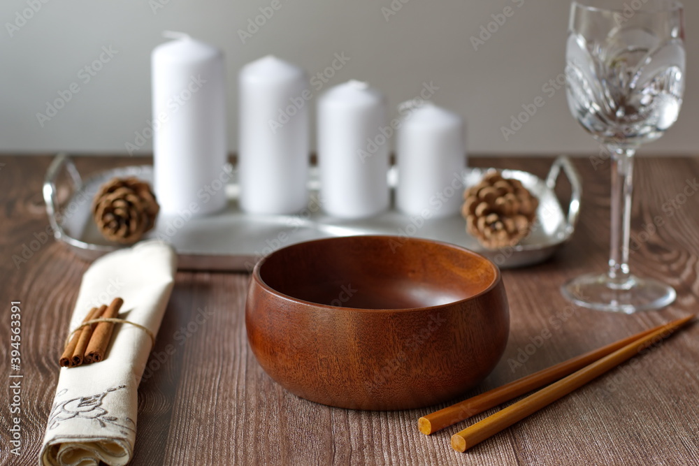 Rustic table layout with wooden bowl and candles on wooden background