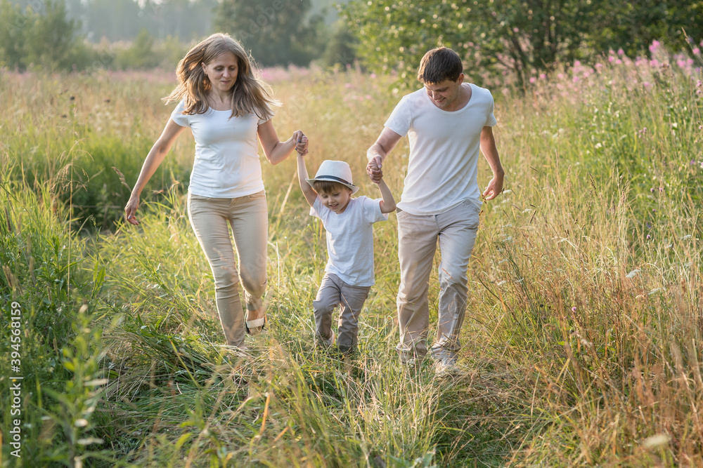 Happy family enjoying walk together at meadow in summer Happy family enjoying walk together at meadow in summer