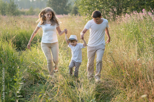 Happy family enjoying walk together at meadow in summer