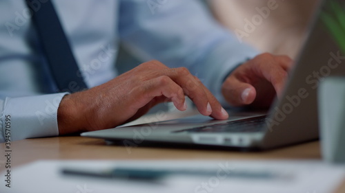 Businessman hands using touchpad on laptop. Fingers moving across touchpad area