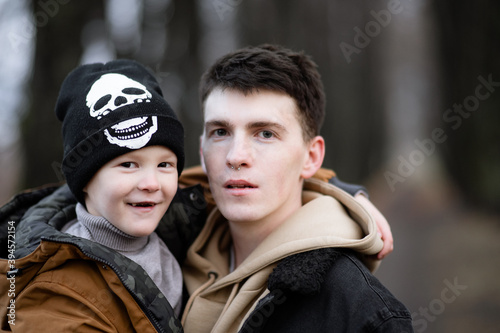 father with nose piercing is raising a child, modern society, large portrait of father and son, son growing up in an informal family © Maxim