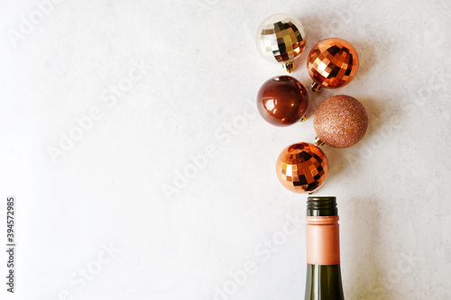 Champagne bottle with golden and brown christmas balls. Flat lay, top view trendy holiday concept. copy space