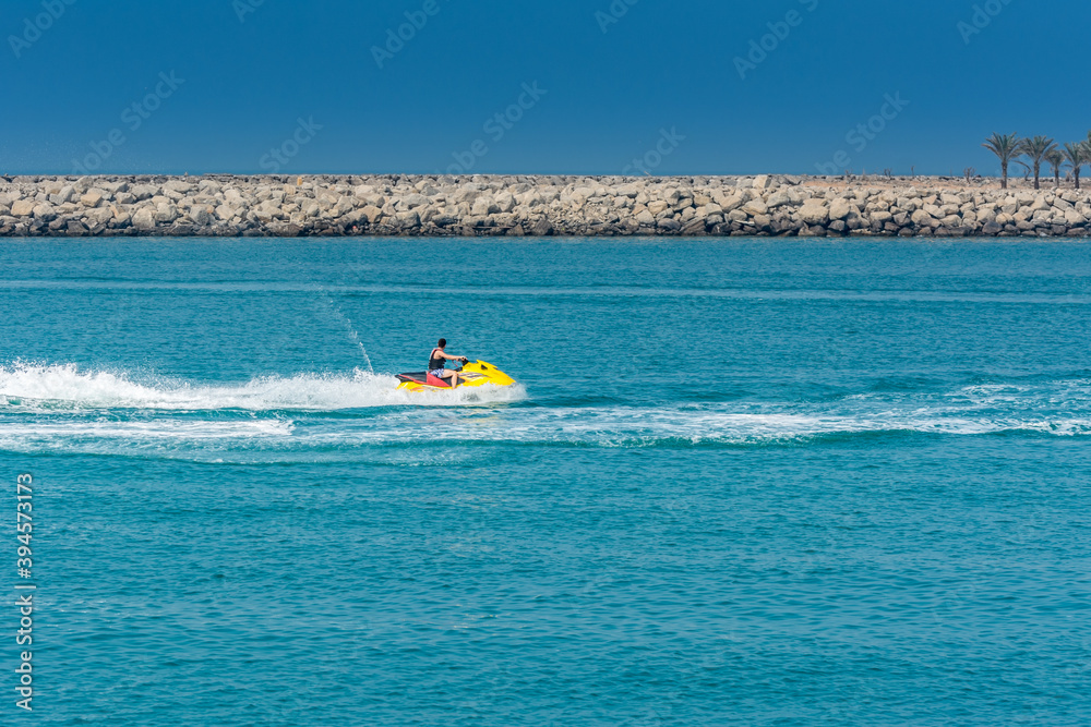 Tourist riding jet ski in the Persian bay in Abu Dhabi, United Arab Emirates