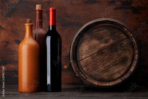 Wine bottles and old wooden barrel