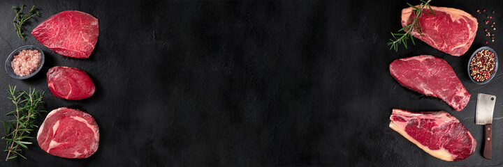 Meat panorama. Various beef steaks, shot from the top on a black background with copy space