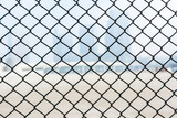 Steel wire mesh as a fence with blurred background of skylines.