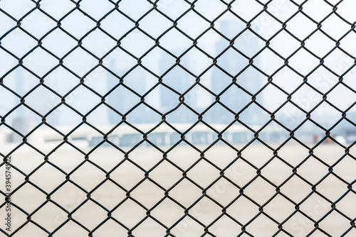 Steel wire mesh as a fence with blurred background of skylines.