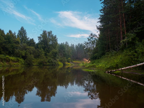 Mirror surface of the river water surface in the middle of the forest. Silence in unique natural locations far from civilisation.