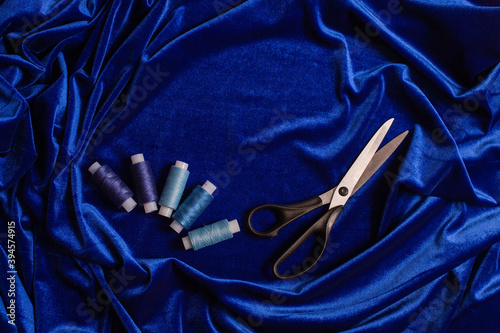 scissors and nitkin blue velvet background photo