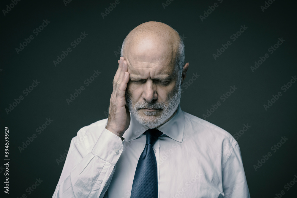Fototapeta premium Exhausted stressed businessman having a bad headache