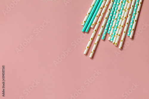 Biodegradable drinking straws for party isolated on pink background. Top view flat lay background. Copy space.