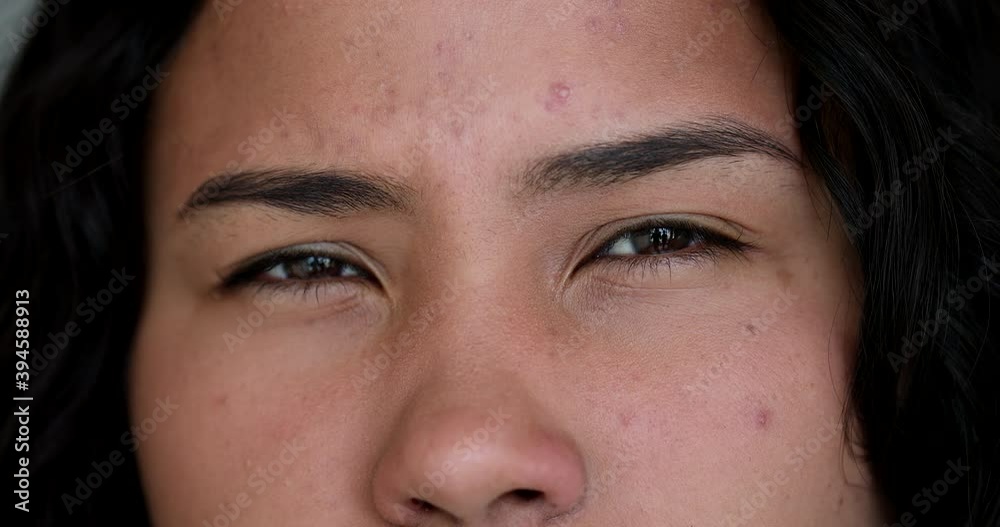 Doubtful girl eyes looking at camera squinting. Suspicious woman macro closeup Doubtful girl eyes looking at camera squinting. Suspicious woman macro closeup