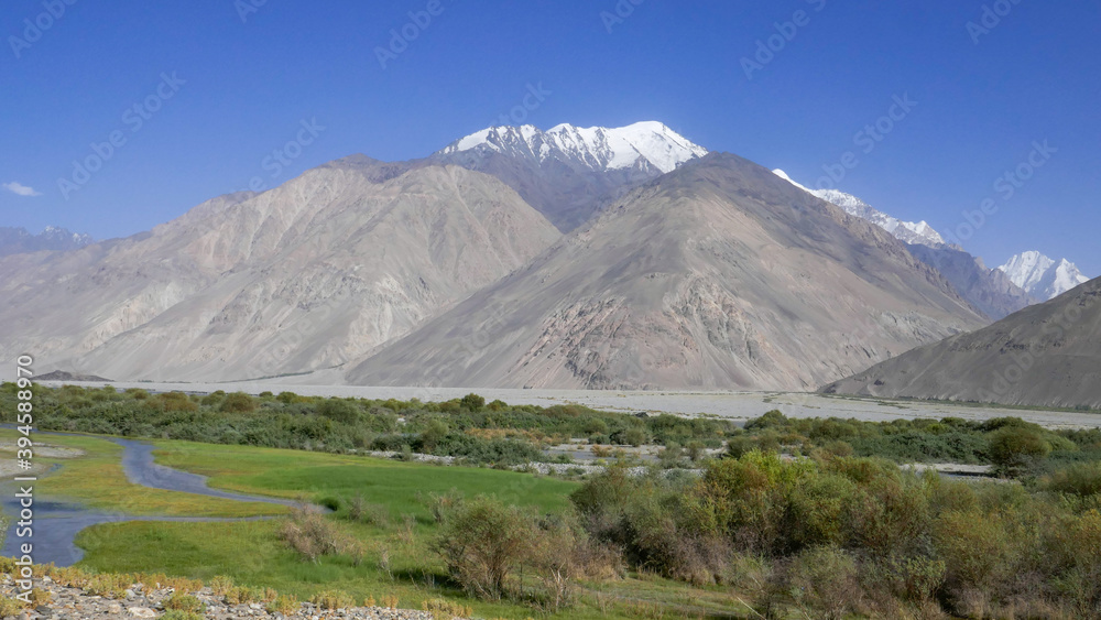 View of the Hindu Kush snow-capped mountains on the Afghan side of the Panj river valley around  Langar village, Wakhan Corridor, in Gorno-Badakshan, the Pamir region of Tajikistan