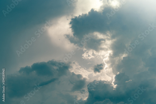 Gray sky and fluffy clouds with sunlight. Cloudy sky. Background for death and sad concept. Sad and moody sky. Nature background. Cloudscape. Hope in darkness day. Overcast sky. Sunlight behind clouds