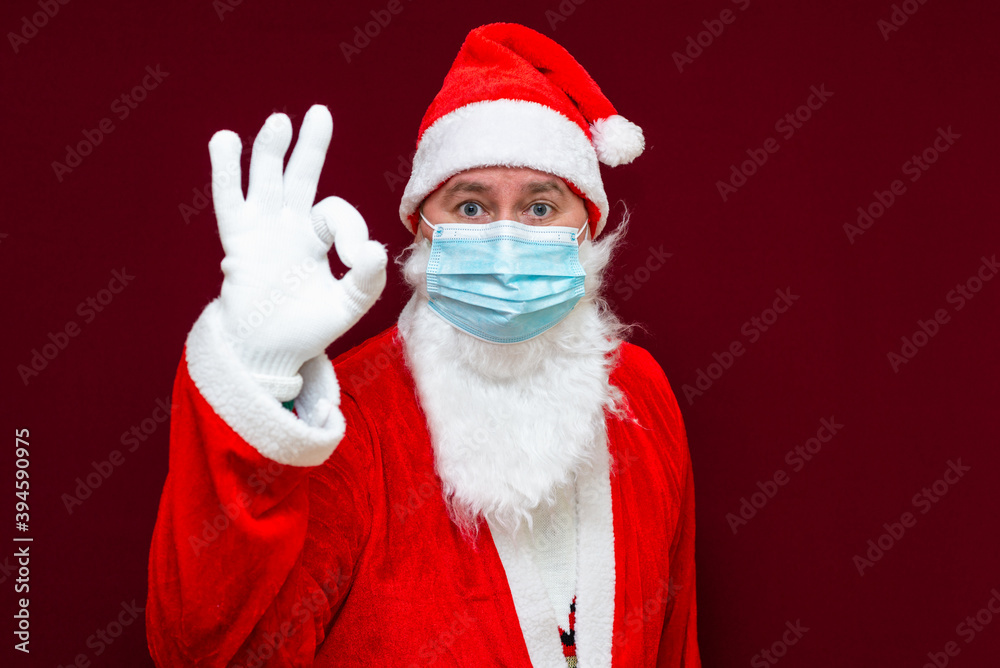 Santa Claus man wears face mask shows gesture ok. coronavirus covid-19 during quarantine. Santa Claus man wears face mask shows gesture ok. coronavirus covid-19 during quarantine.