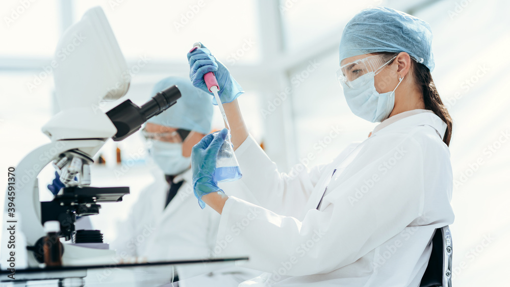 close up. laboratory technician testing liquid in a laboratory flask . close up. laboratory technician testing liquid in a laboratory flask .