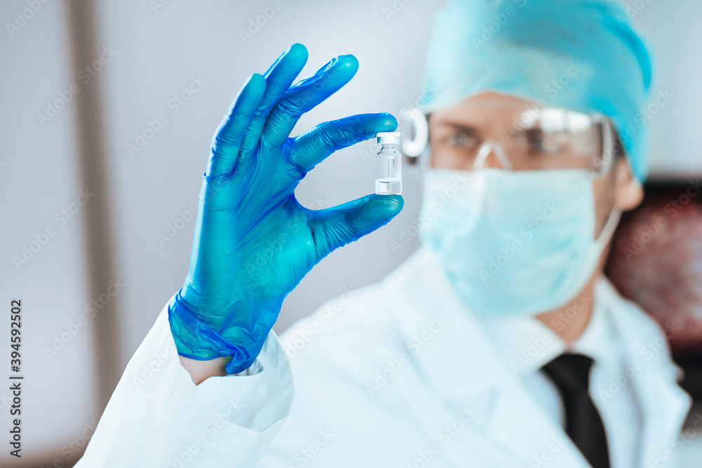 close up. scientist looking at a capsule with a new vaccine. close up. scientist looking at a capsule with a new vaccine.