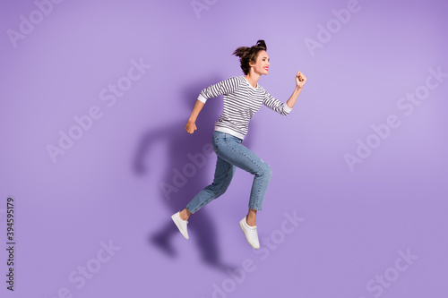 Full length photo of lovely slim lady dressed casual clothes jumping running isolated purple color background