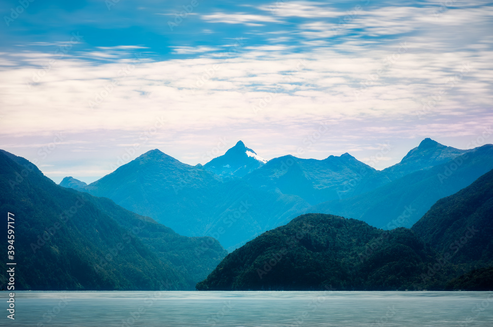 Morning Aurora (dawn light) rising behind the mountains in the wilderness of the Deep Cove at Doubtful Sound, a fjord in New Zealand, South Island. Morning Aurora (dawn light) rising behind the mountains in the wilderness of the Deep Cove at Doubtful Sound, a fjord in New Zealand, South Island.