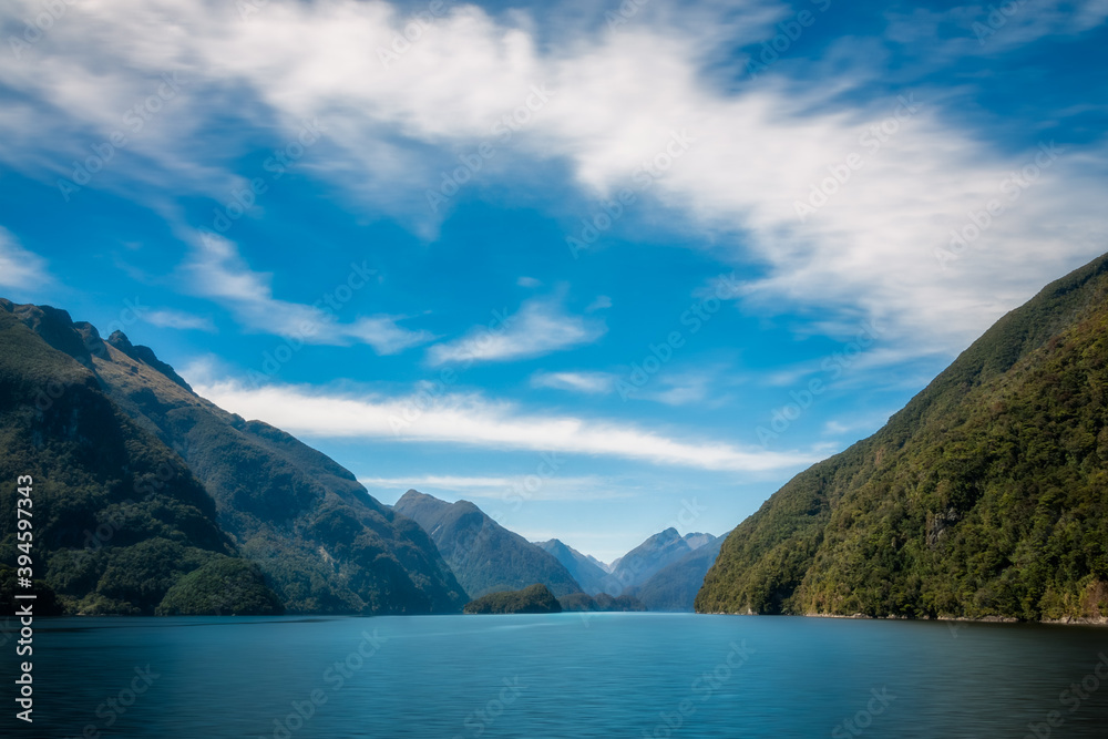 Mountain range spectacular and exquisite water views in the remote wilderness of the Deep Cove on a beautiful summer morning at Doubtful Sound in New Zealand, South Island.