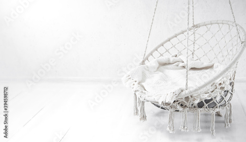 Hygge scene with white hammock chair on white background. Cozy place for weekend relax in the room.
