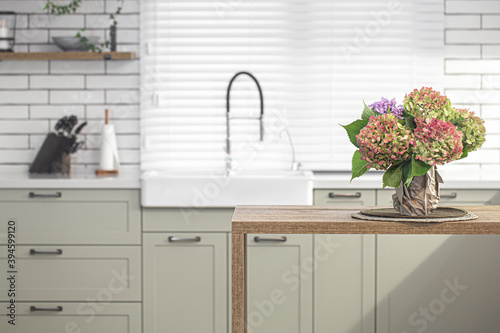 Bouquet of autumn hydrangeas on blurred background of modern kitchen interior.