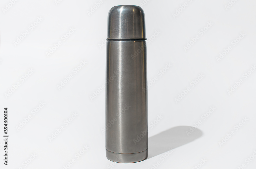 Vacuum steel thermos on white background, indoors. Travel concept, camping accessories Vacuum steel thermos on white background, indoors. Travel concept, camping accessories