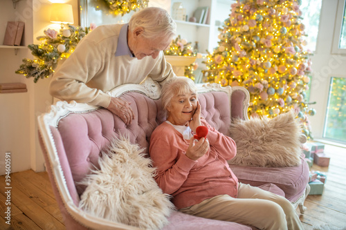 Grey-haired man giving a gift to a surprised woman