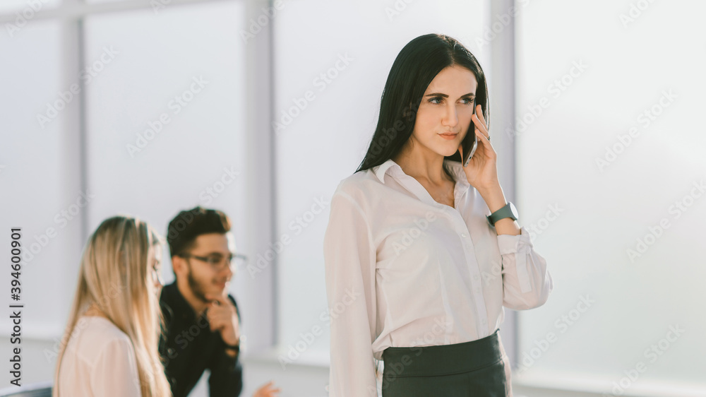 serious business woman talking on cell phone in office serious business woman talking on cell phone in office