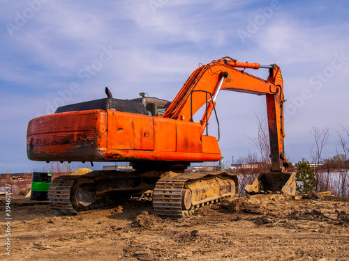 Powerful orange excavator in rural area