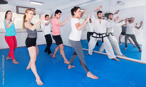 Young adult trainees practicing new maneuvers in a karate class