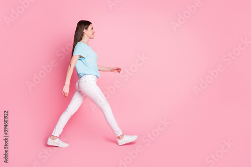 Full body profile side photo of nice girl walk copyspace isolated over pink color background © deagreez