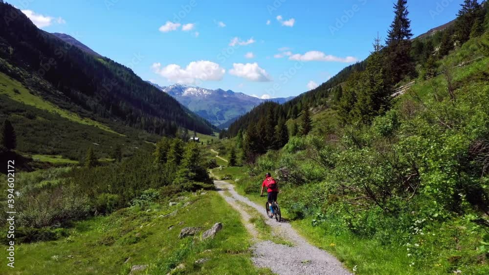 Aerial view of man riding down a trail with the bike Aerial view of man riding down a trail with the bike