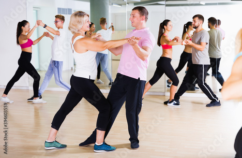 Happy of different ages people having dancing class in classroom