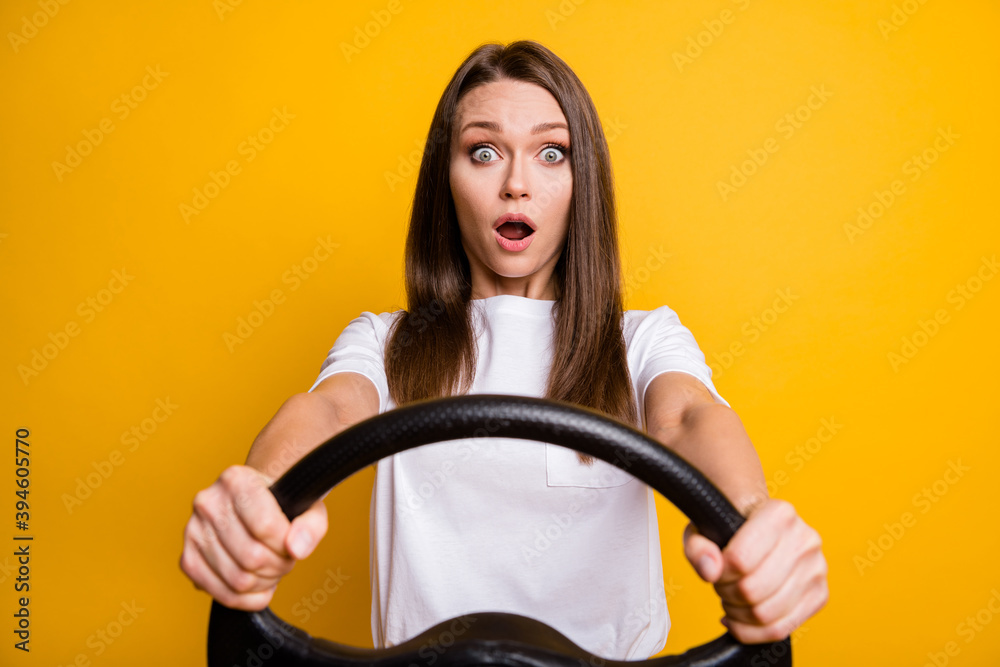 Photo portrait of afraid fear brunette girl holding steering wheel driving first time isolated vivid yellow color background Photo portrait of afraid fear brunette girl holding steering wheel driving first time isolated vivid yellow color background