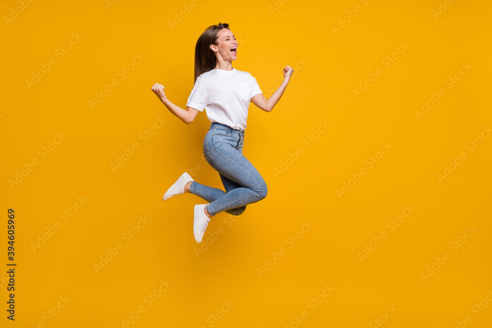 Full length body size photo of cheerful overjoyed girl fan jumping gesturing like winner yelling isolated bright yellow color background