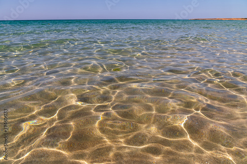 crystal clear sea water in shallow water with sun glare abstract background blur in motion