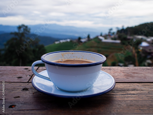 Hot tea in the cup on wood table with mountain view background