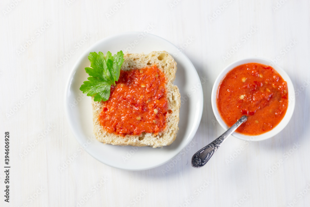 Open sandwich with sauce of red chilli pepper, tomato, salt, vinegar, olive oil in white bowl Open sandwich with sauce of red chilli pepper, tomato, salt, vinegar, olive oil in white bowl