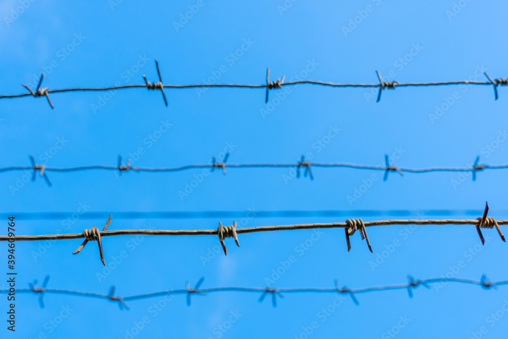 Barbed wire horizontally against the blue sky. Barbed wire horizontally against the blue sky.