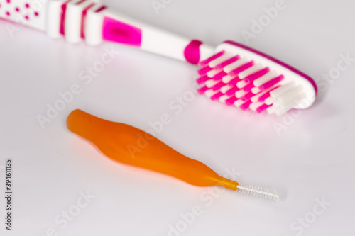 Interdental brush against the usual toothbrush  closeup in selective focus